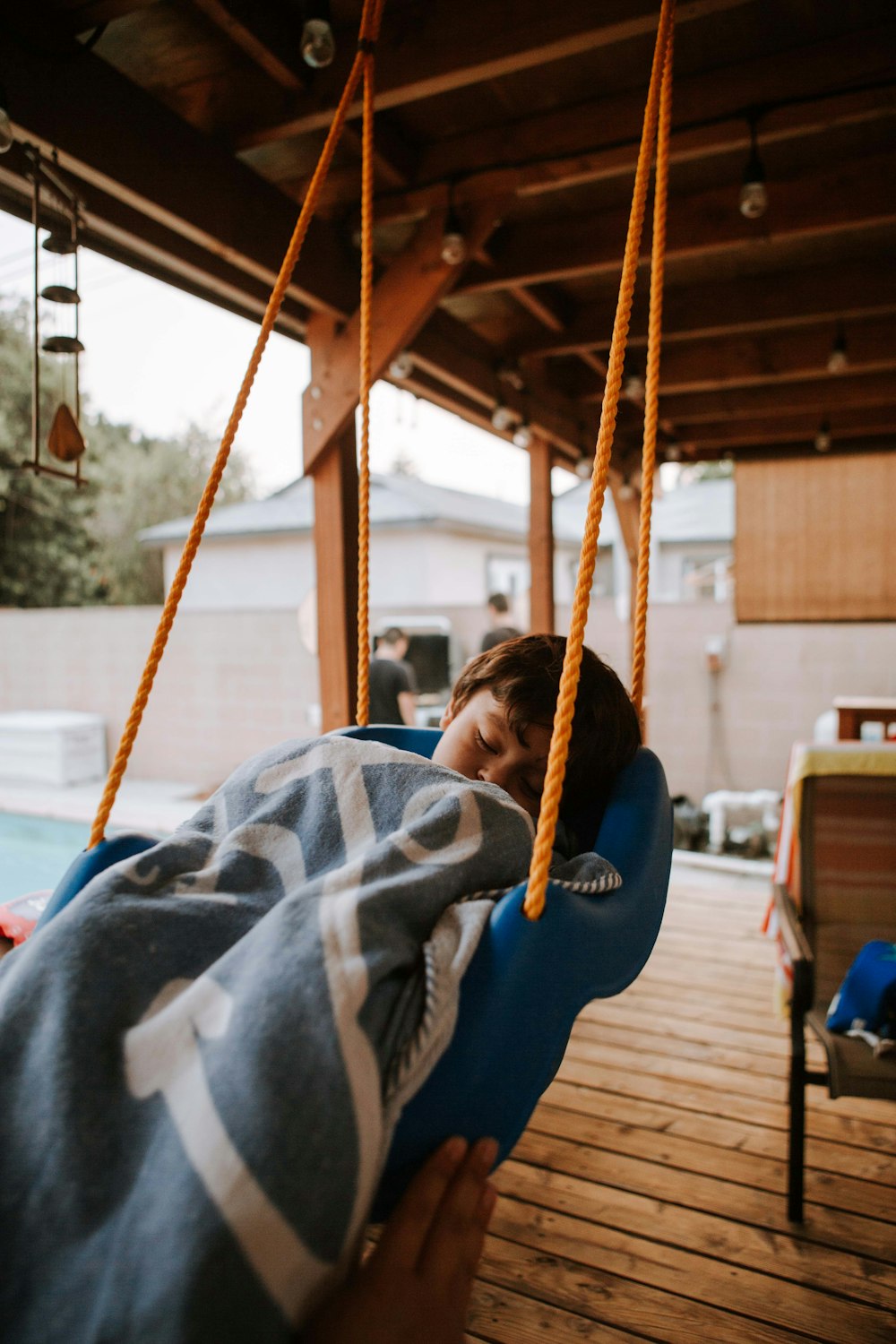 person in blue jacket sitting on swing during daytime