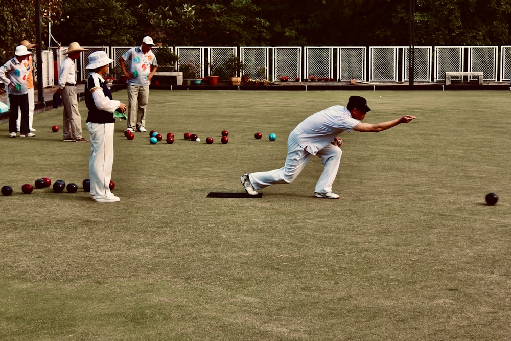 man in white shirt and white pants playing golf during daytime