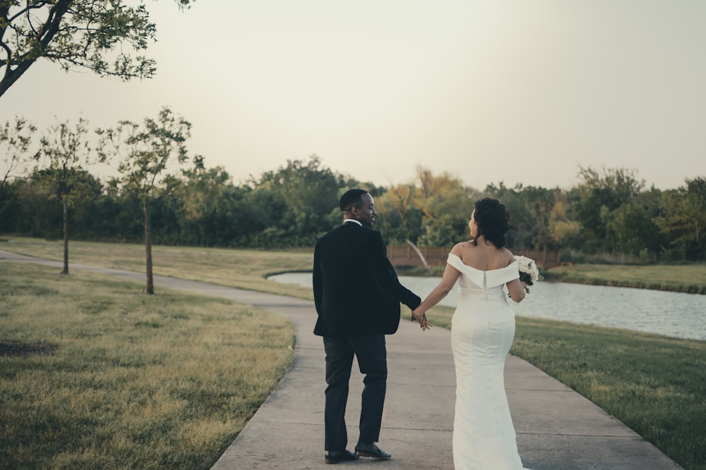 man and woman holding hands while walking on road during daytime