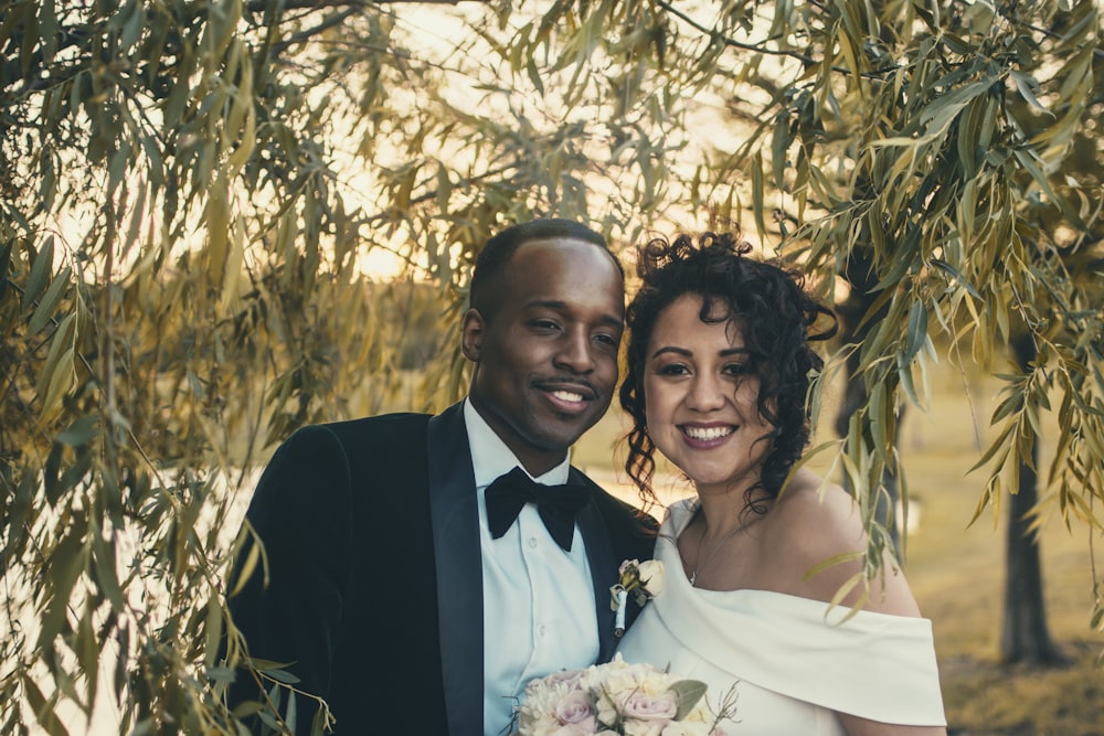 man in black suit jacket beside woman in white wedding dress