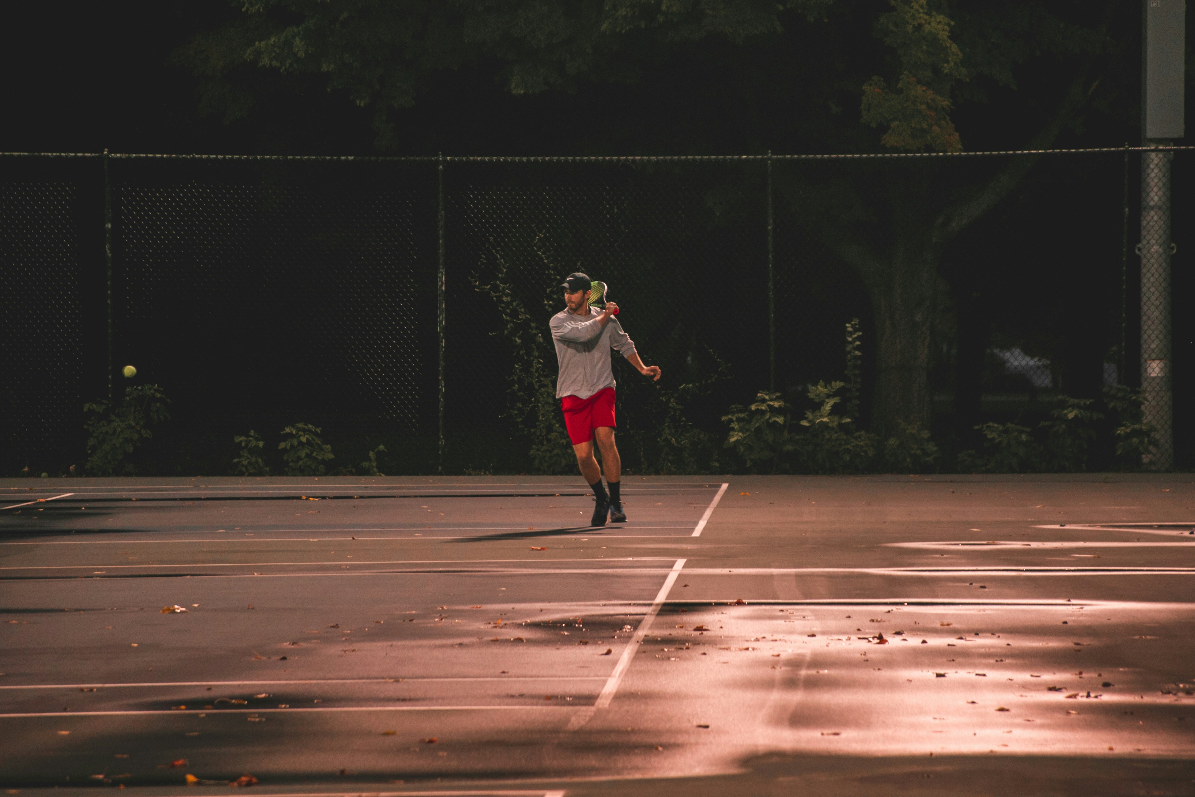 Man playing tennis at sunset in Milwaukee, WI.