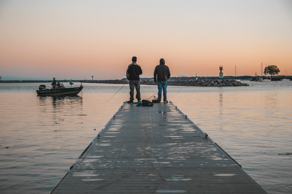 man and woman walking on wooden dock during daytime