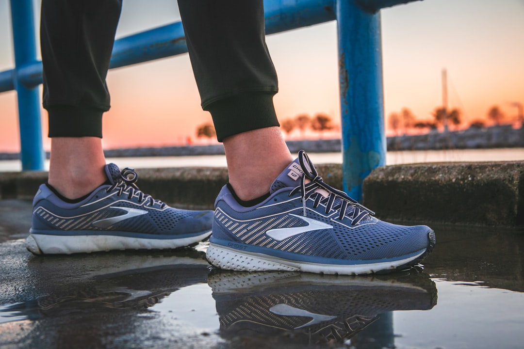 person wearing blue and white running shoes