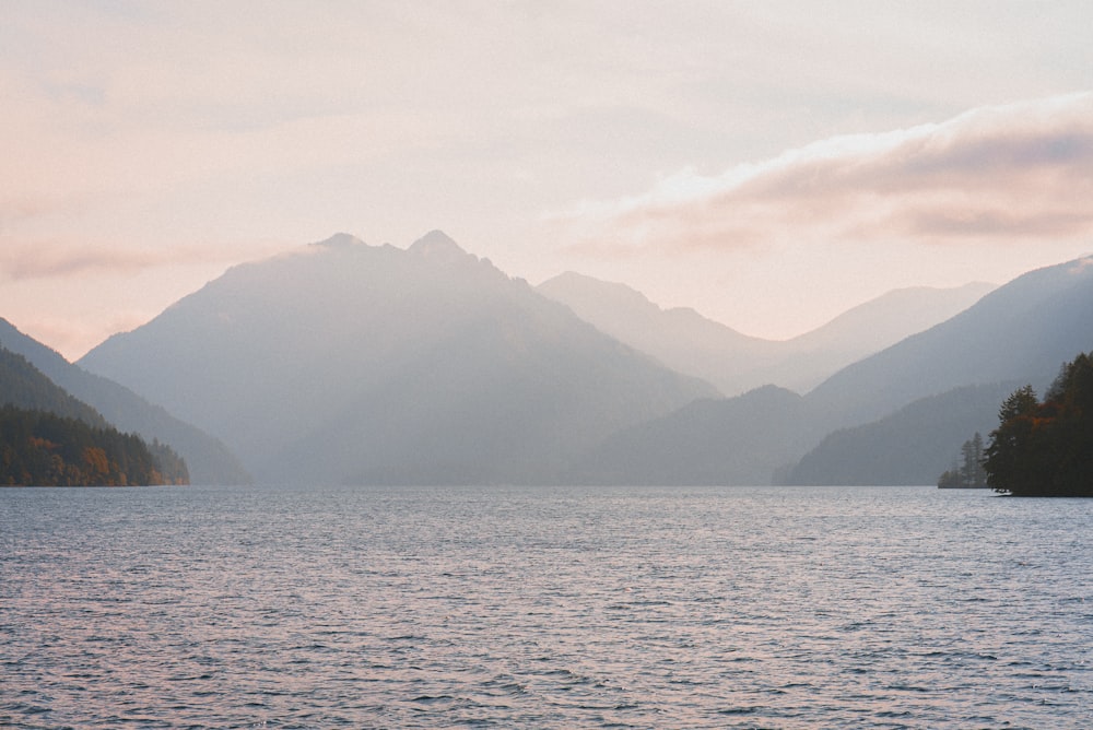 body of water near mountain during daytime