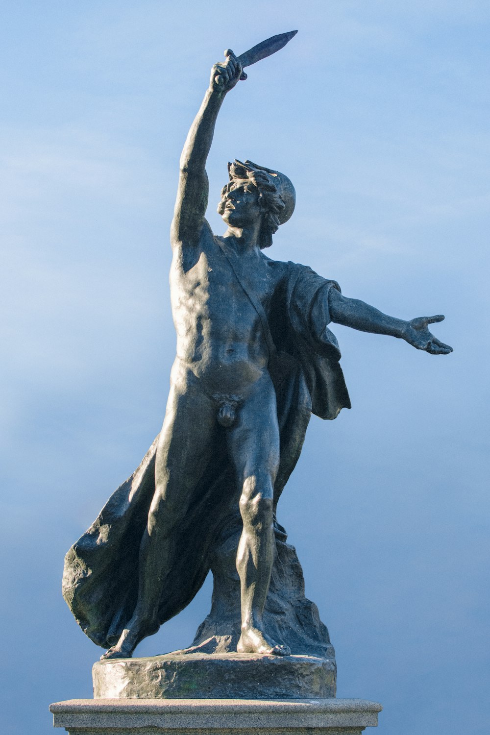 man with wings statue under blue sky during daytime