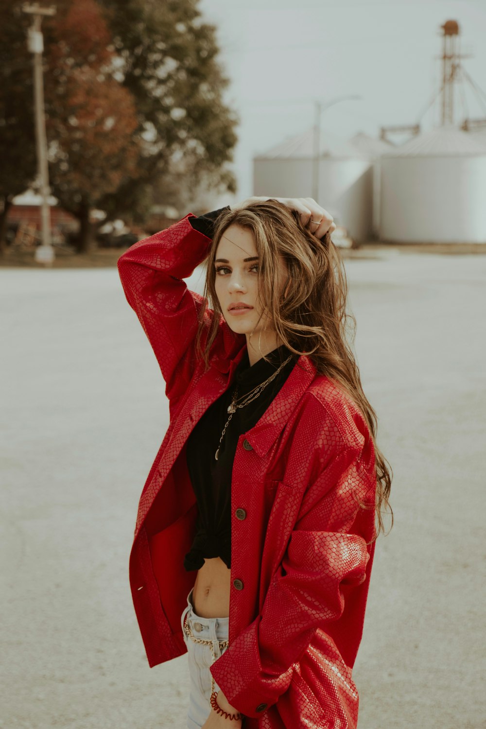 woman in red coat standing on snow covered ground during daytime