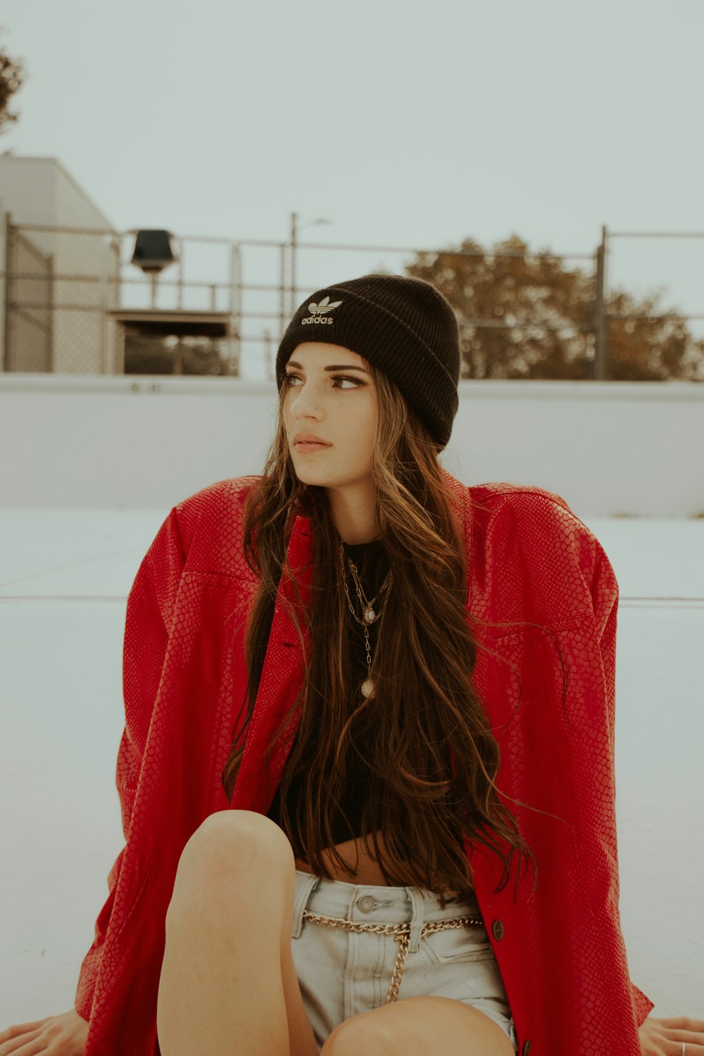 woman in red and black jacket wearing black knit cap