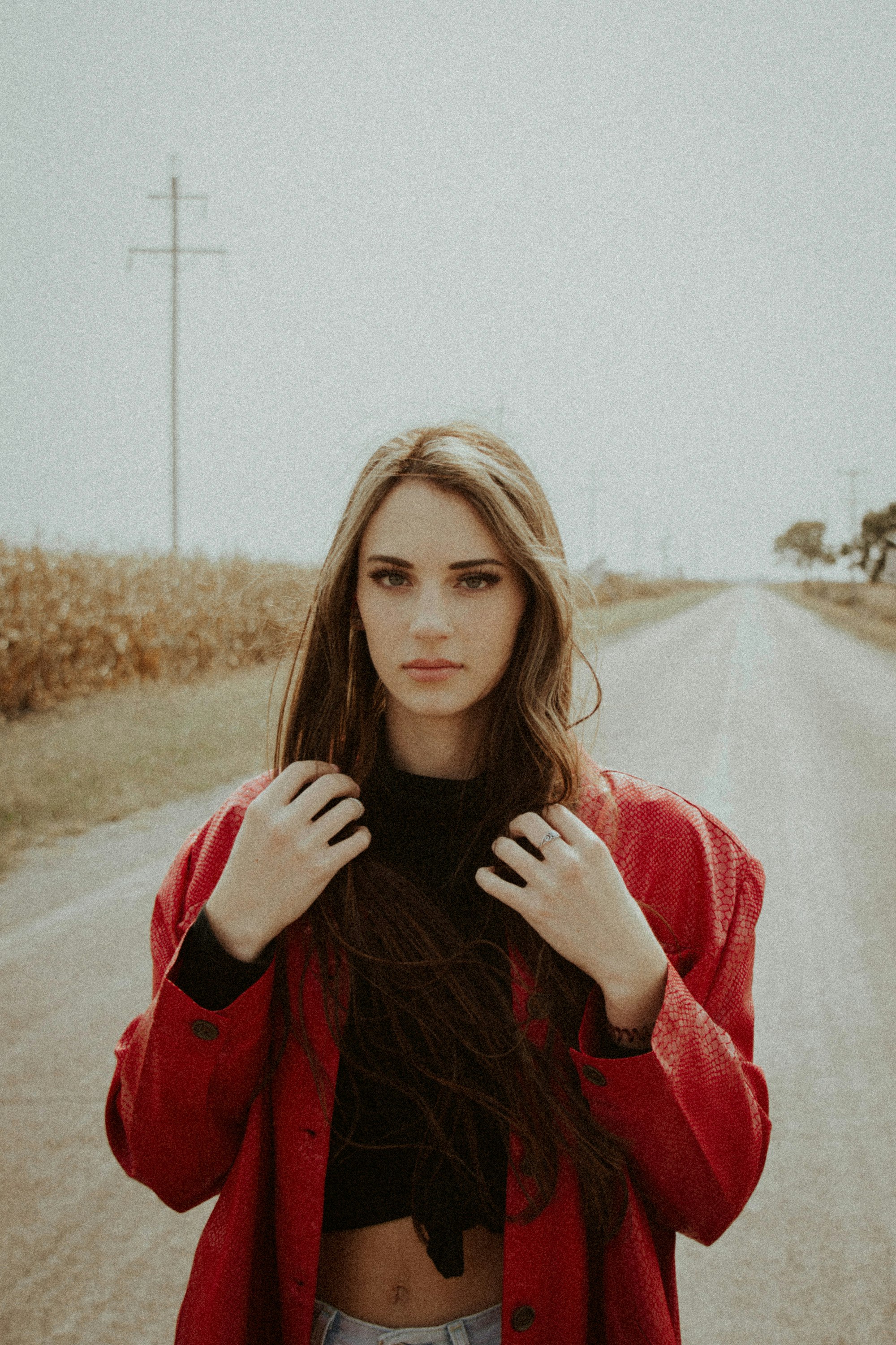 woman in red long sleeve shirt standing on brown field during daytime