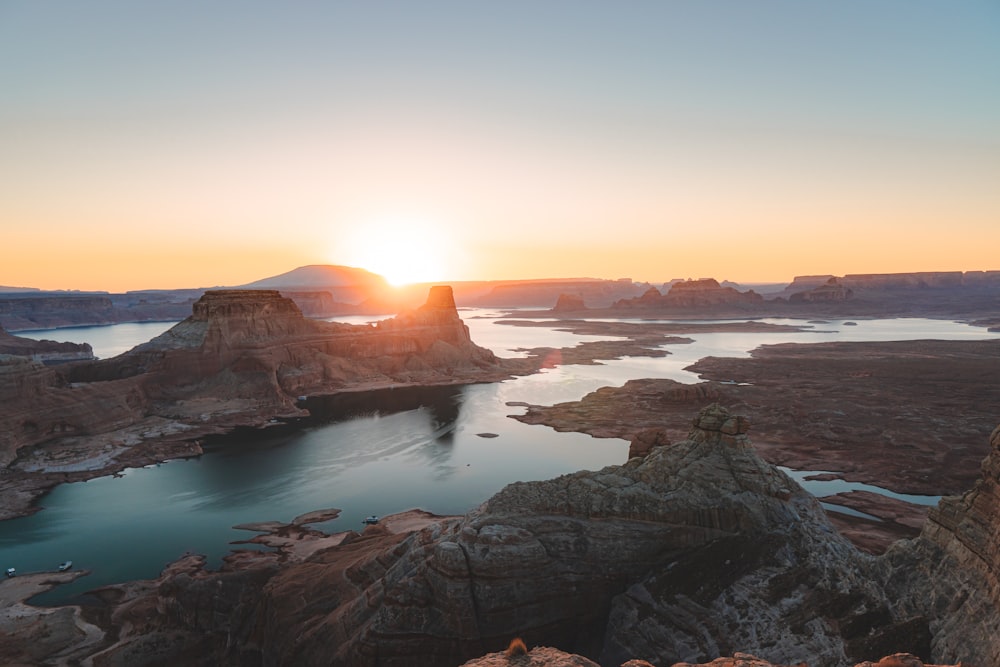 brown rocky mountain beside body of water during sunset