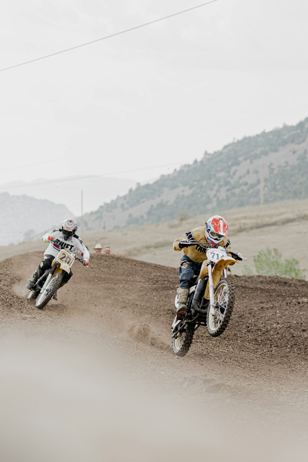 man in orange helmet riding motocross dirt bike