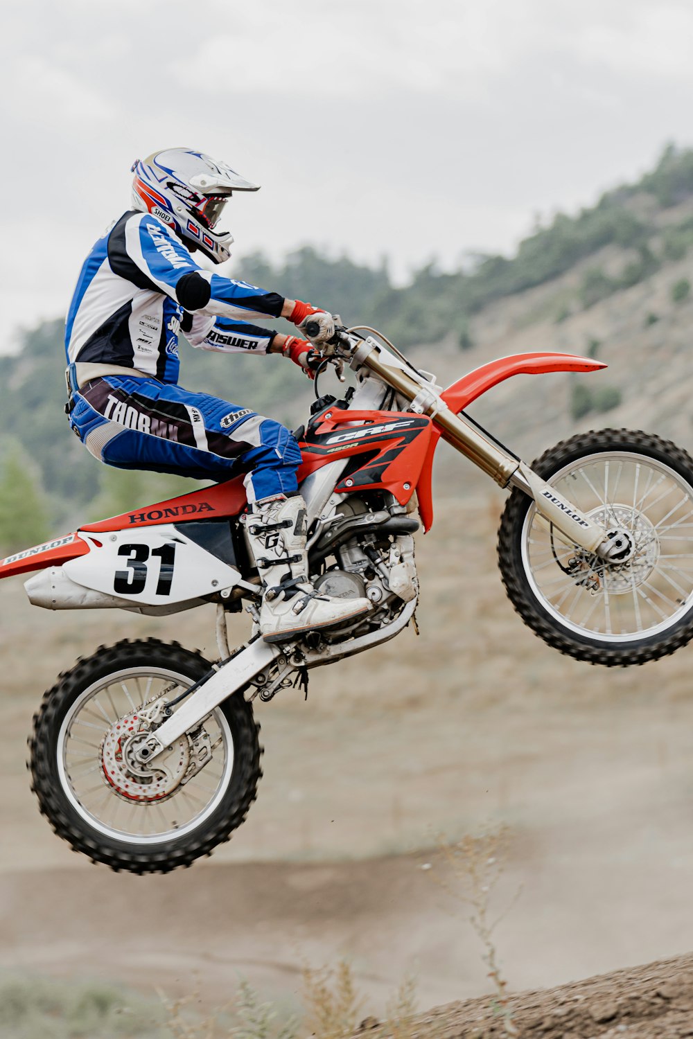 man in blue and white motocross suit riding motocross dirt bike