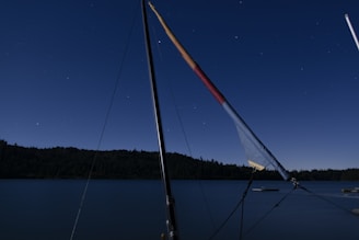 A sleek sailboat navigating through digital waves under a starry night sky filled with glowing AI symbols.