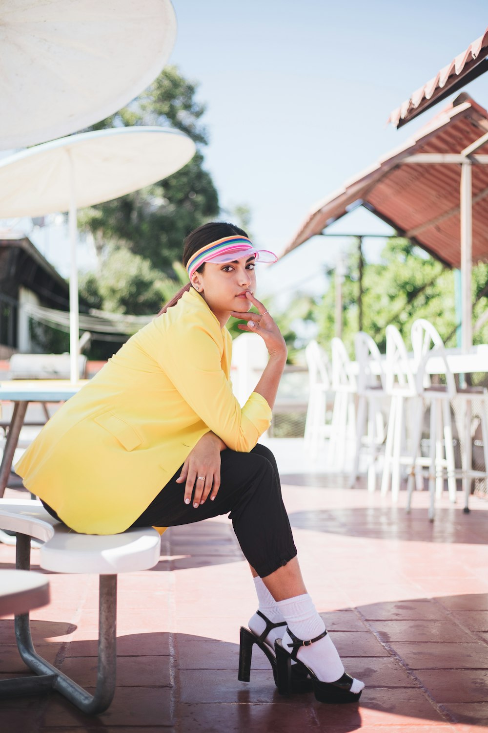 woman in yellow long sleeve shirt and black skirt sitting on white chair