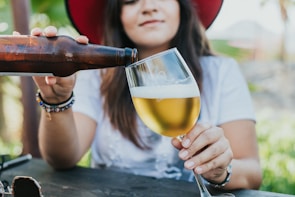 Close-up of a participant chugging a beer with determination on a sunny day