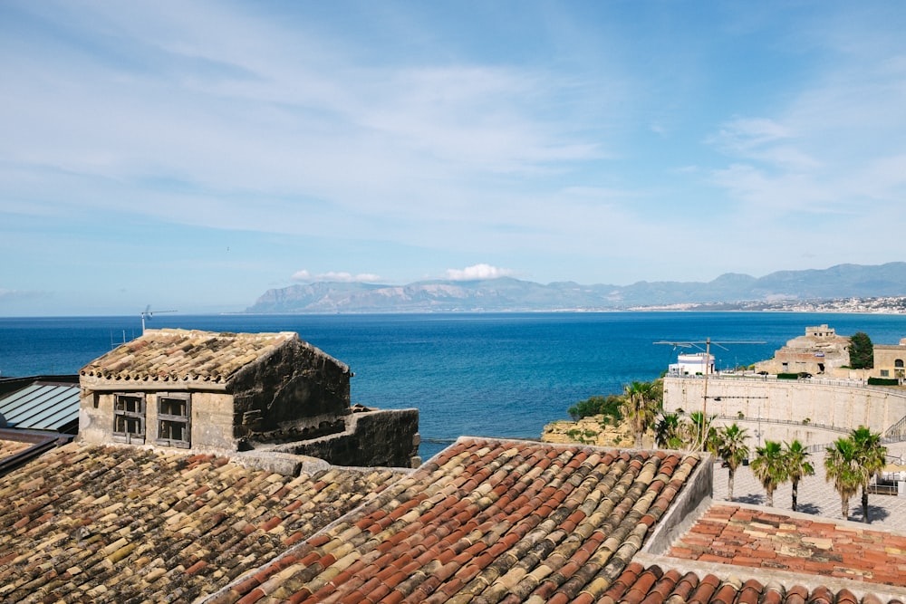 Casa in cemento marrone e bianco vicino allo specchio d'acqua durante il giorno