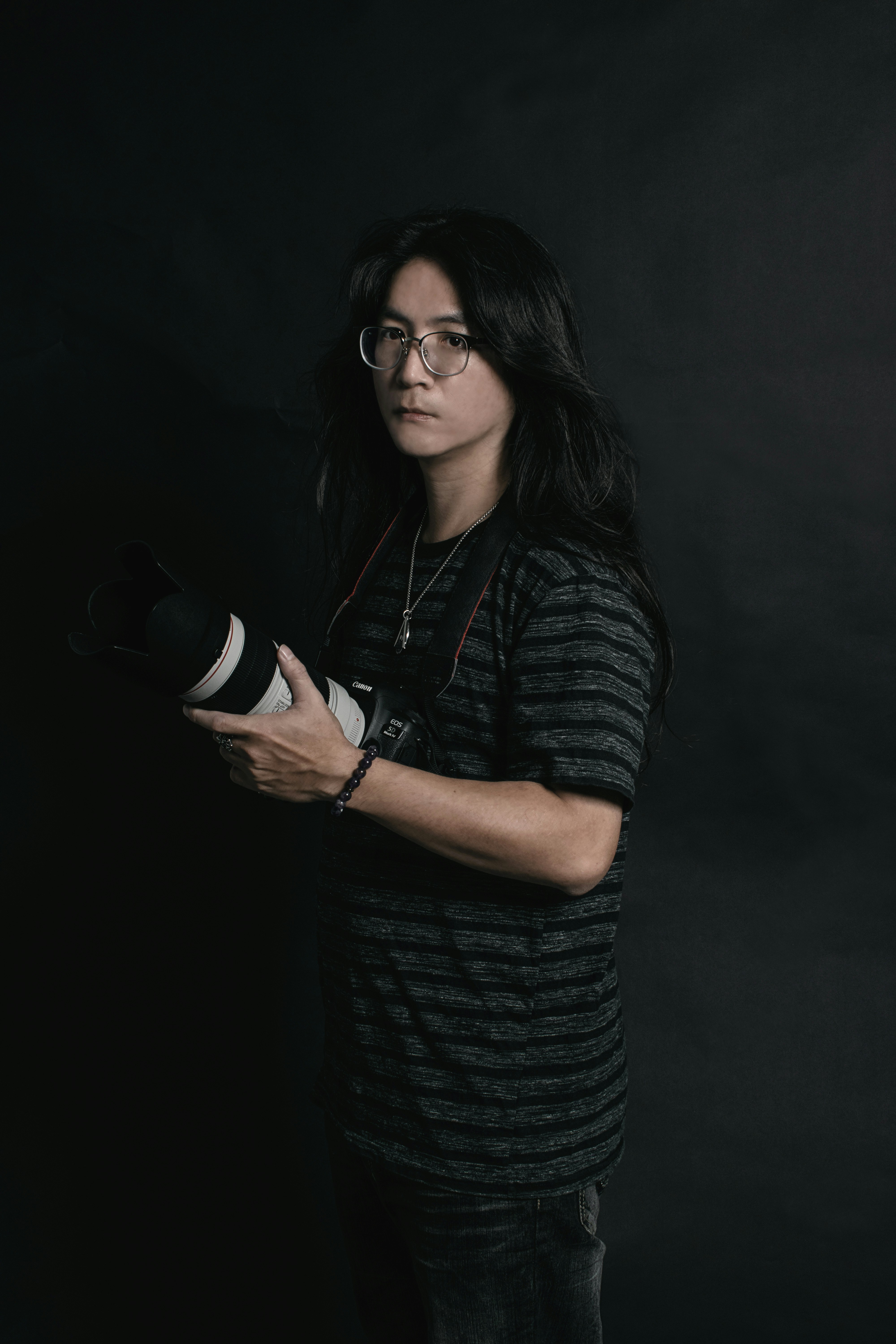 woman in black and gray stripe shirt wearing black framed eyeglasses