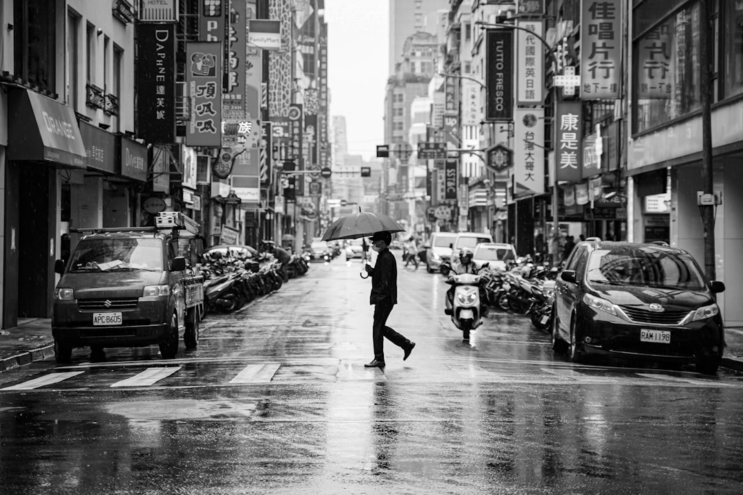grayscale photo of man walking on street