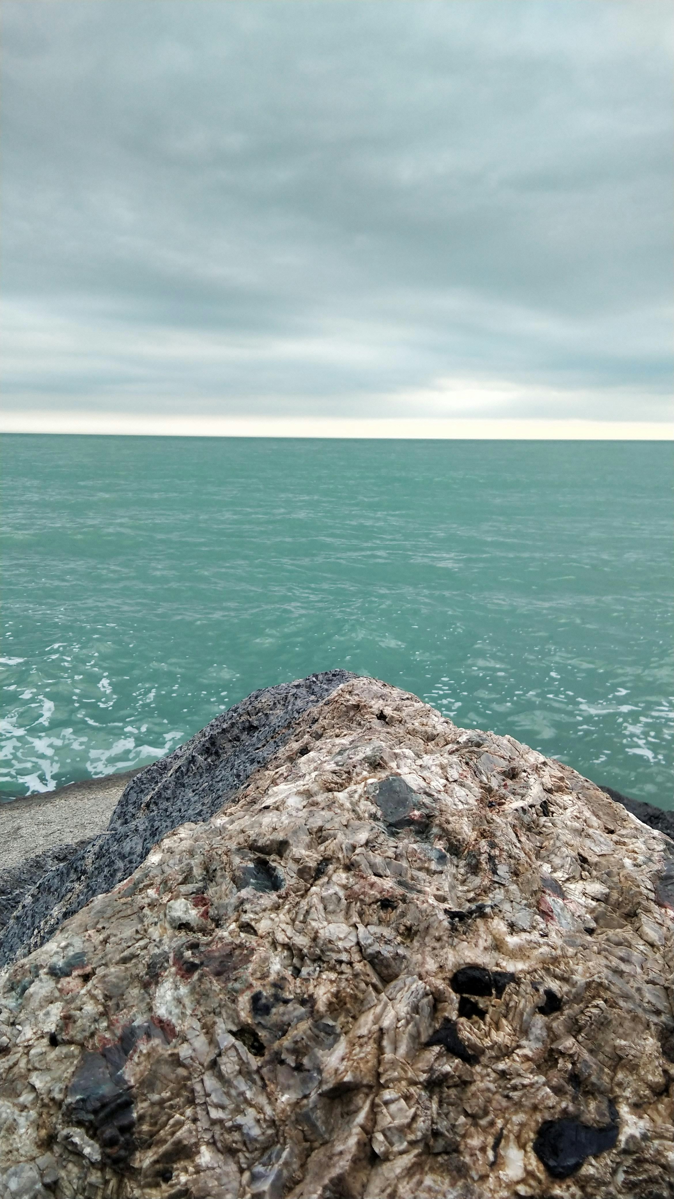 brown rock formation near body of water during daytime