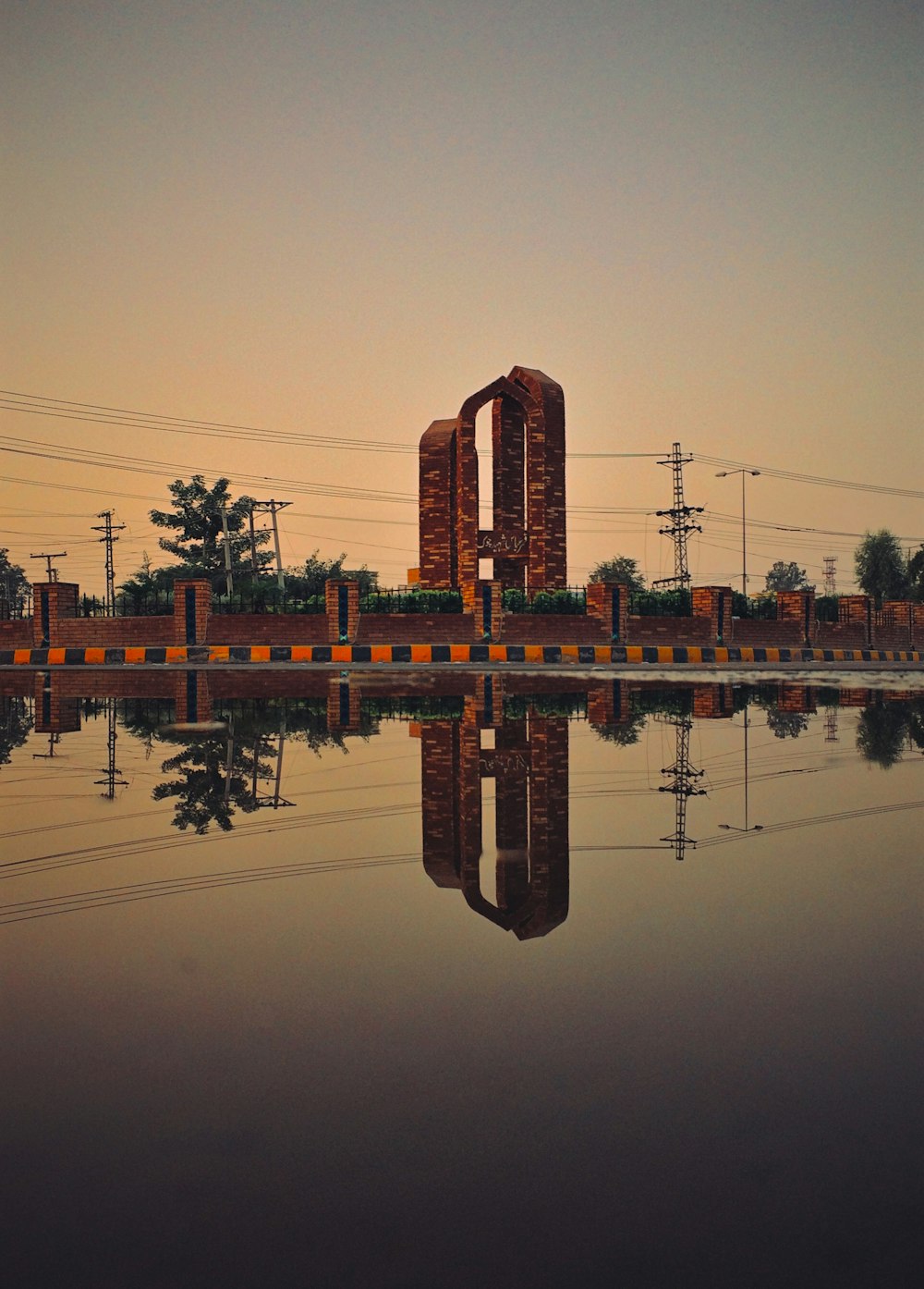 reflection of red and yellow tower on water during daytime