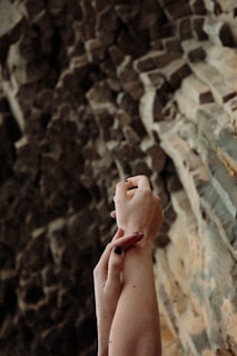 persons hand on brown and white wall