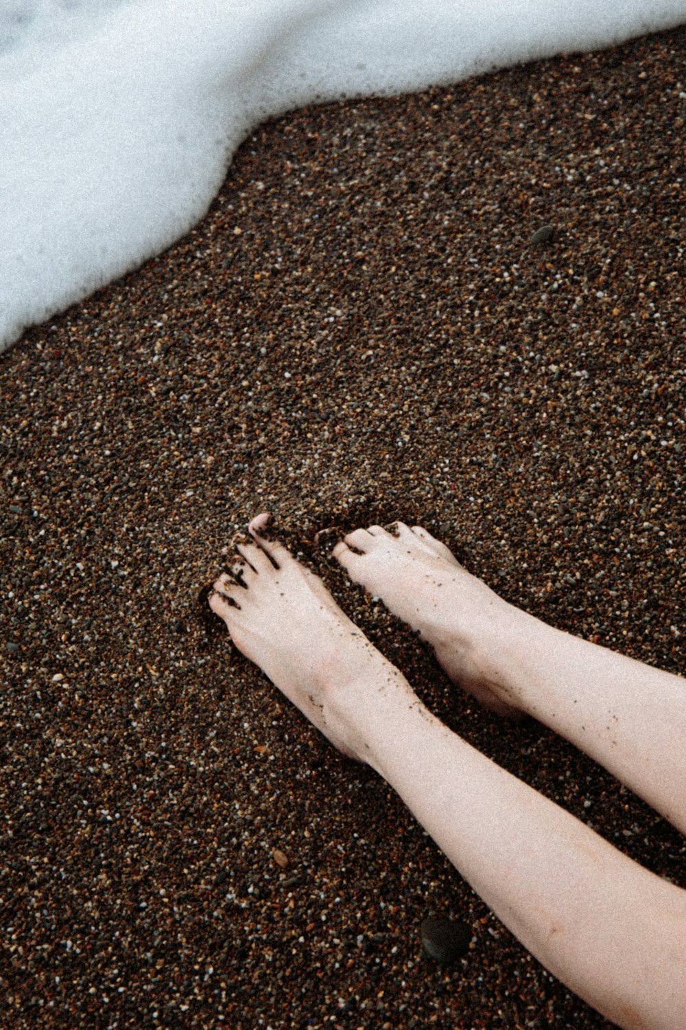 persons feet on brown sand