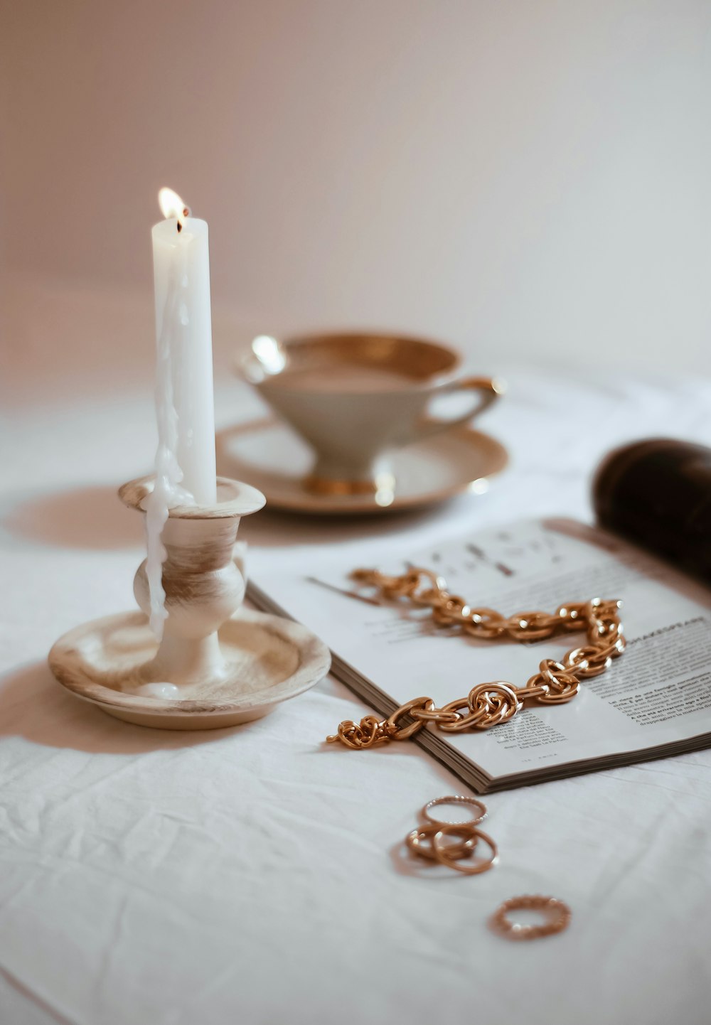 gold and silver cross on white ceramic candle holder