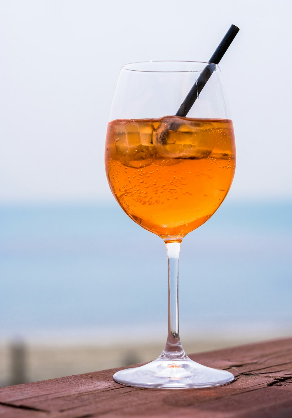 Copa de vino transparente con líquido de naranja