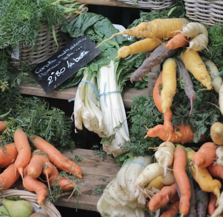 carrots and green leafy vegetable on brown woven basket