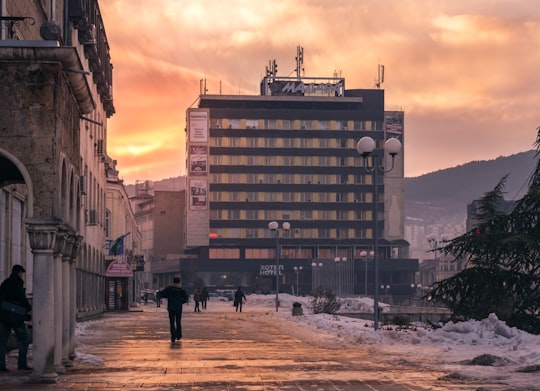 people walking on street near brown concrete building during daytime in Shumen Bulgaria