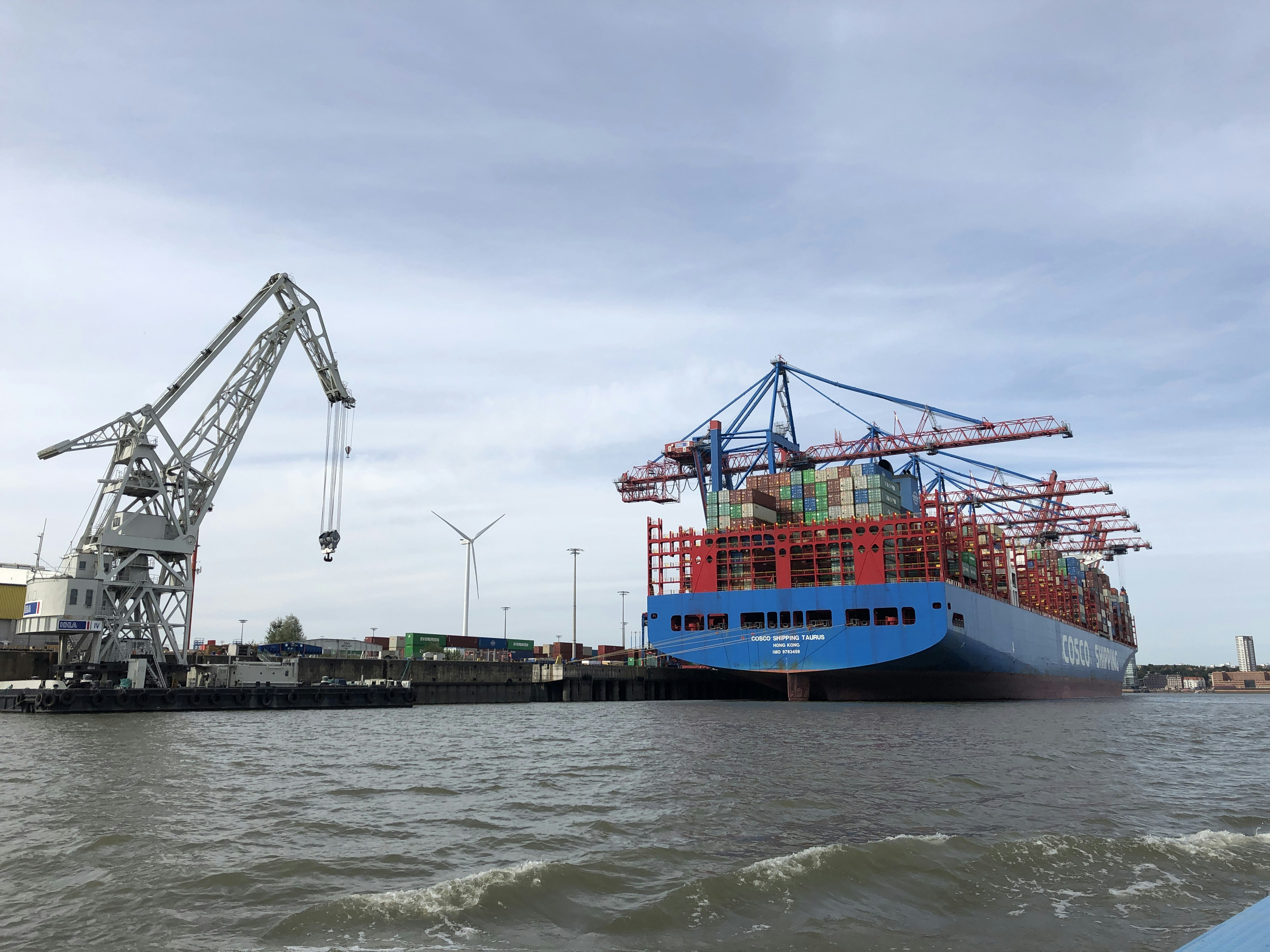 blaues und rotes Frachtschiff tagsüber unter blauem Himmel