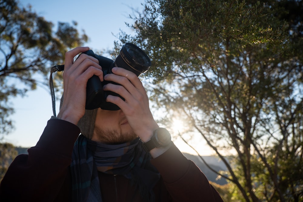 person in black jacket holding black camera