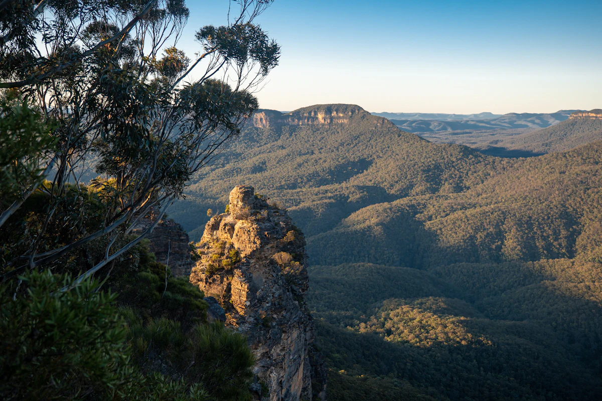 A sandstone pillar near Echo Point in evening light, with the valley and a distant mesa behind