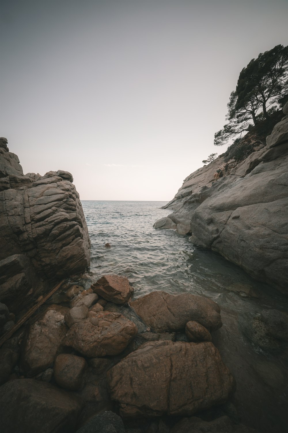 brown rocky mountain beside body of water during daytime