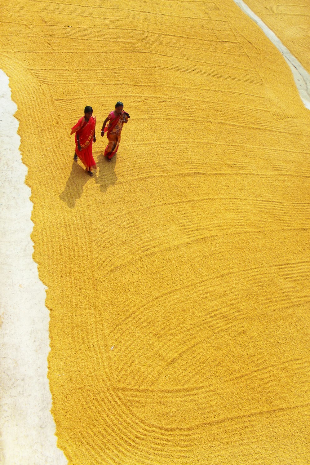 2 women walking on sand during daytime