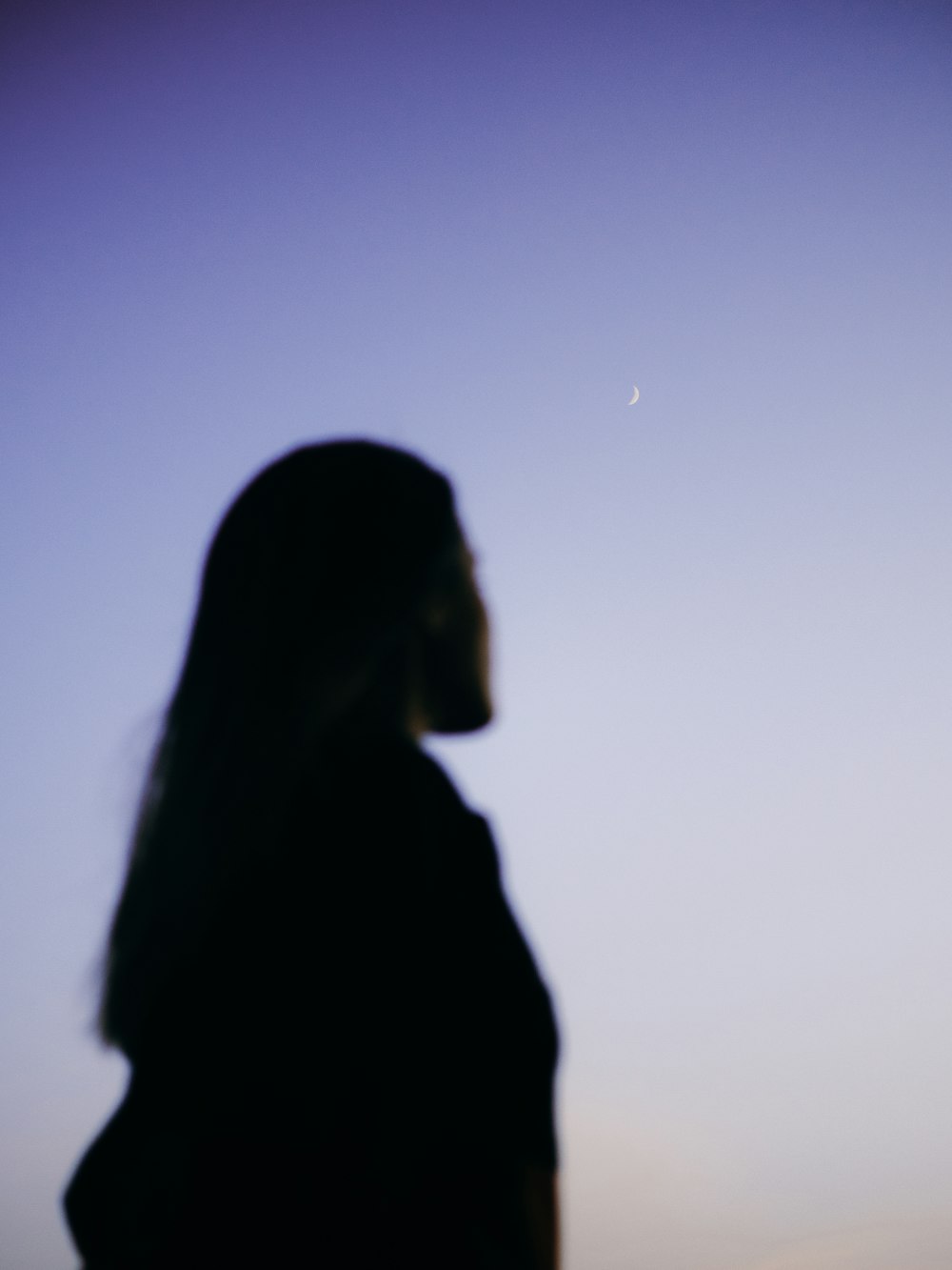 silhouette of woman under blue sky during daytime