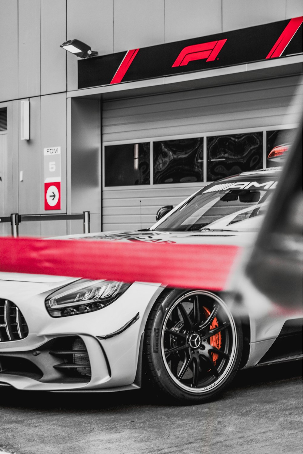 Auto sportiva rossa e bianca in fotografia in scala di grigi