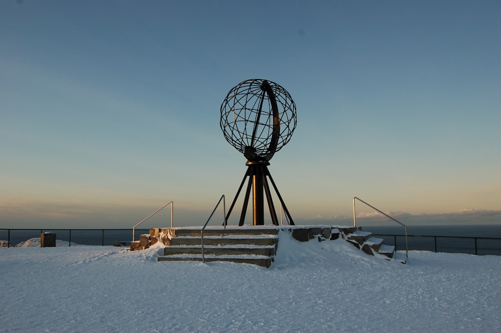 black metal ferris wheel on white snow covered ground during daytime