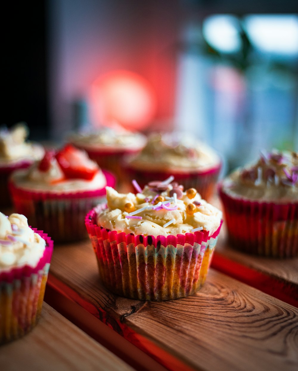 pink cupcake on brown wooden table