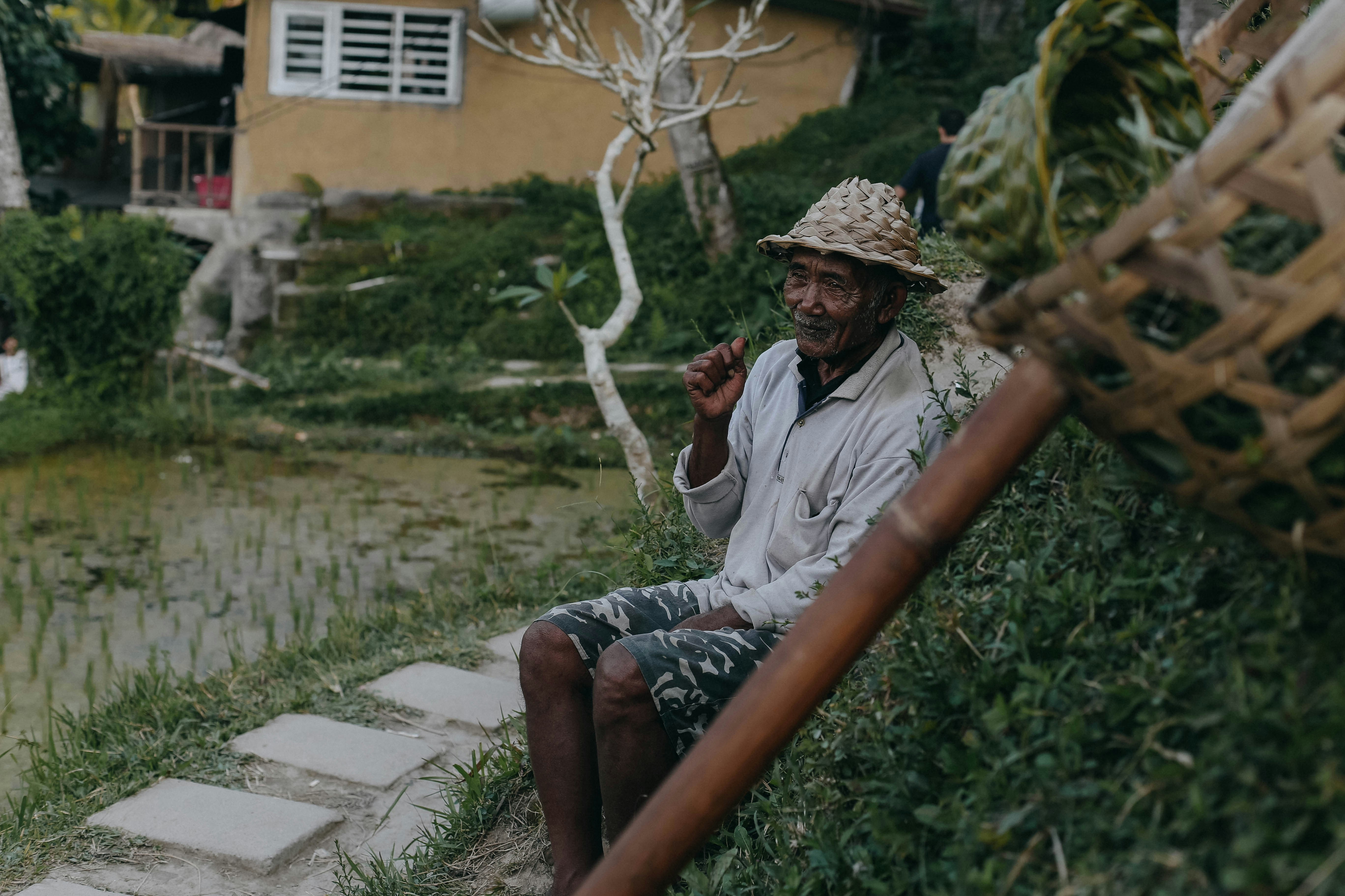 Homme en chemise blanche assis sur un banc en bois brun pendant la journée