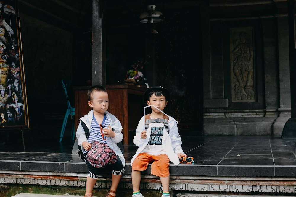 2 boys sitting on brown wooden bench