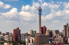 city skyline under blue and white cloudy sky during daytime