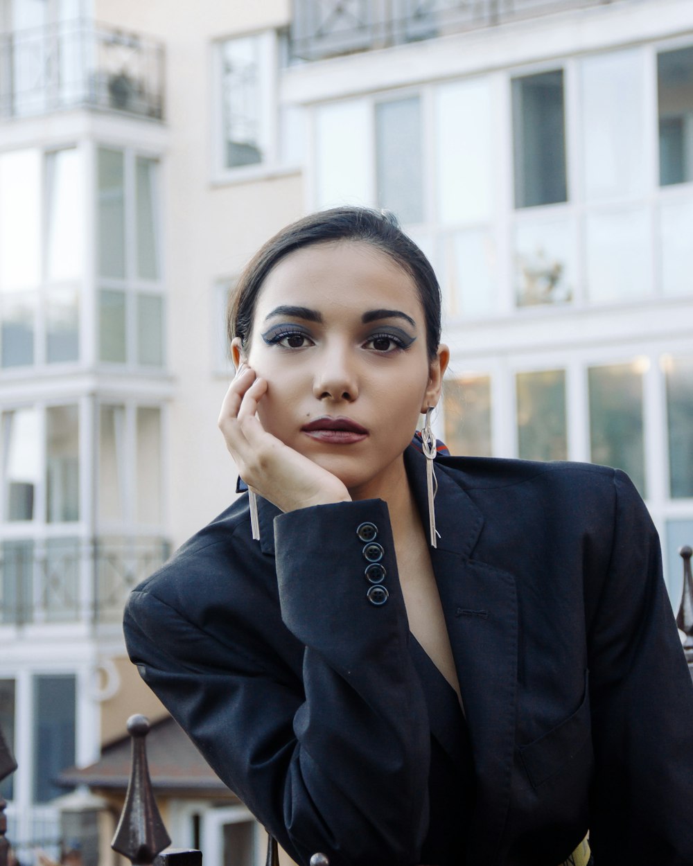 Mujer en blazer negro sosteniendo su cara