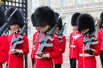 men in red and black uniform holding rifle during daytime