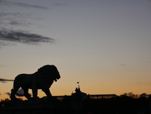 A striking close-up of the lion flag waving with ancient Persian architectural ruins in the background.