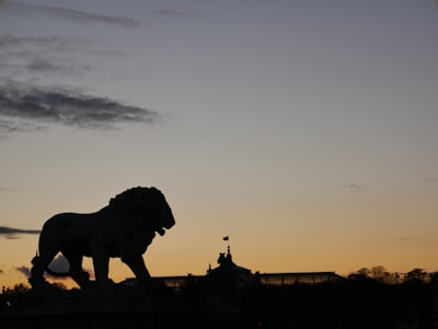 A striking close-up of the lion flag waving with ancient Persian architectural ruins in the background.