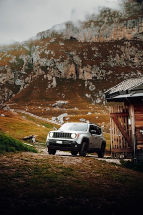 A rugged Japanese SUV ready for adventure, surrounded by green hills.