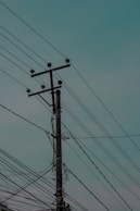 brown electric post under blue sky during daytime