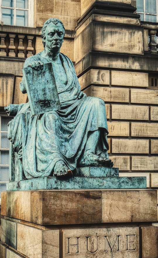 gray concrete statue of man in Gladstone's Land United Kingdom