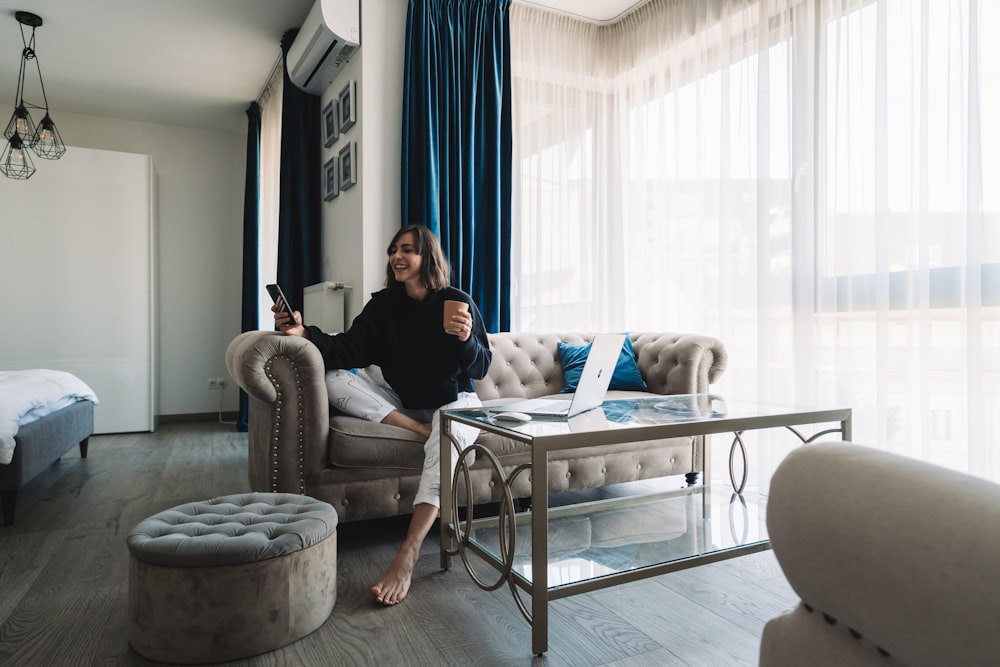 woman in black long sleeve shirt sitting on gray sofa chair