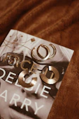 Elegant gold hoop earrings resting beside a vintage book with warm natural light.